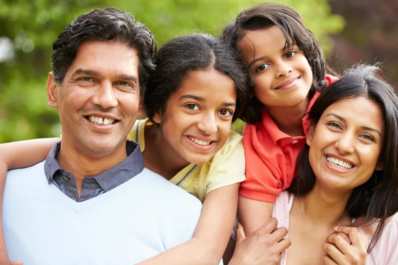 A smiling family of four outdoors
